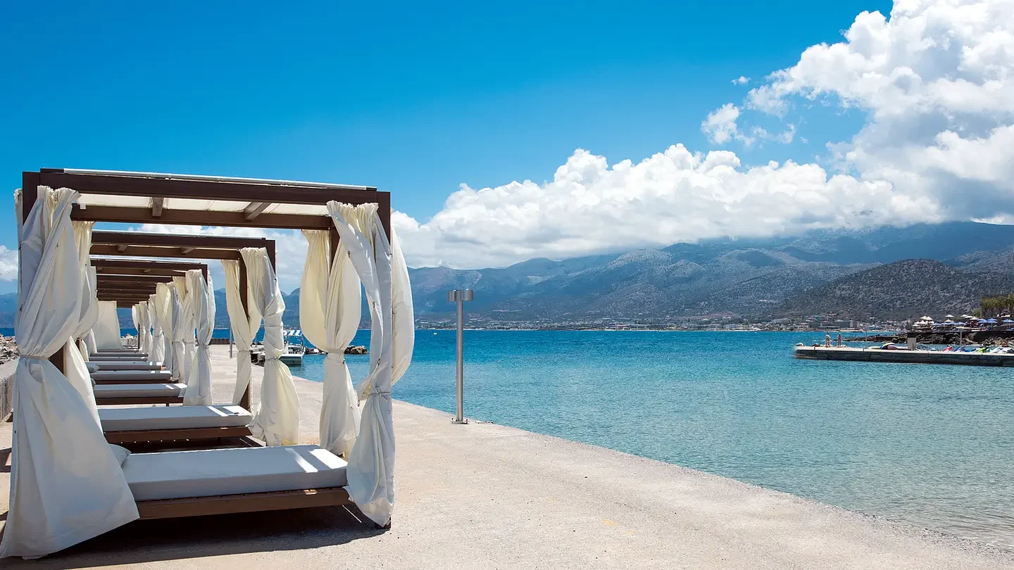 Seafront cabanas with white curtains on the Cretan coast