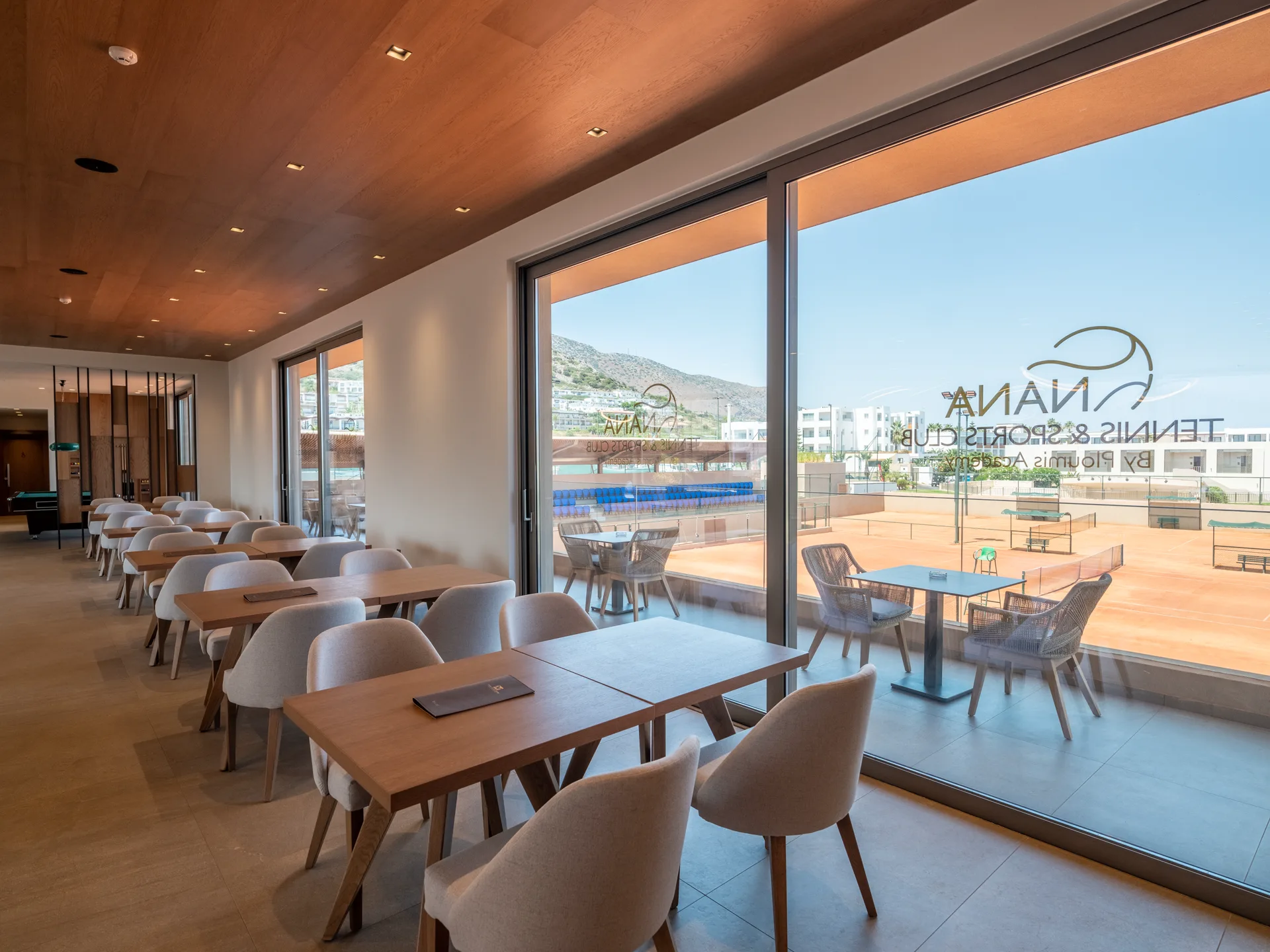 Club lounge windows overlooking the clay tennis courts