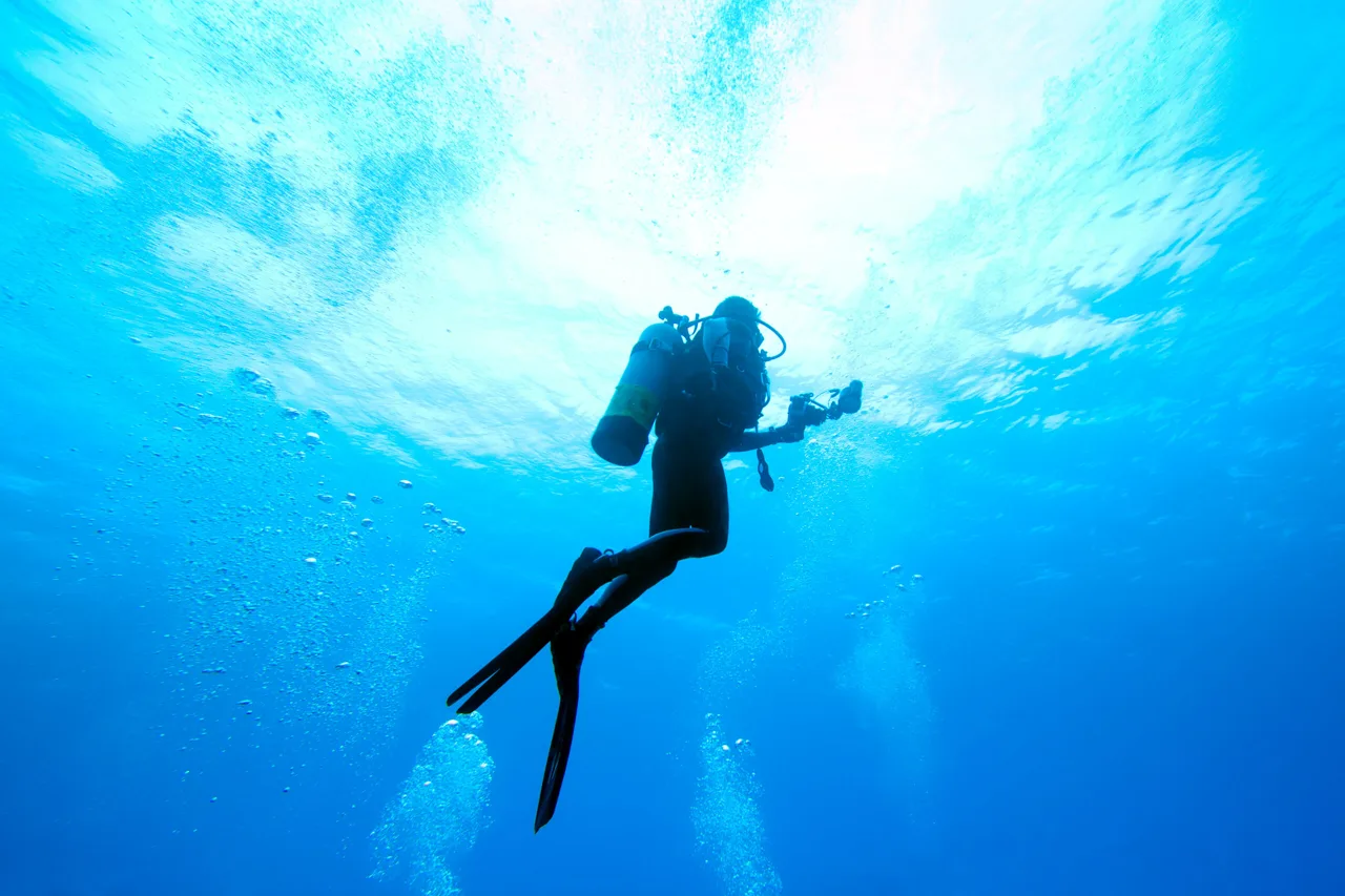 Scuba diver beneath the clear blue waters of Crete