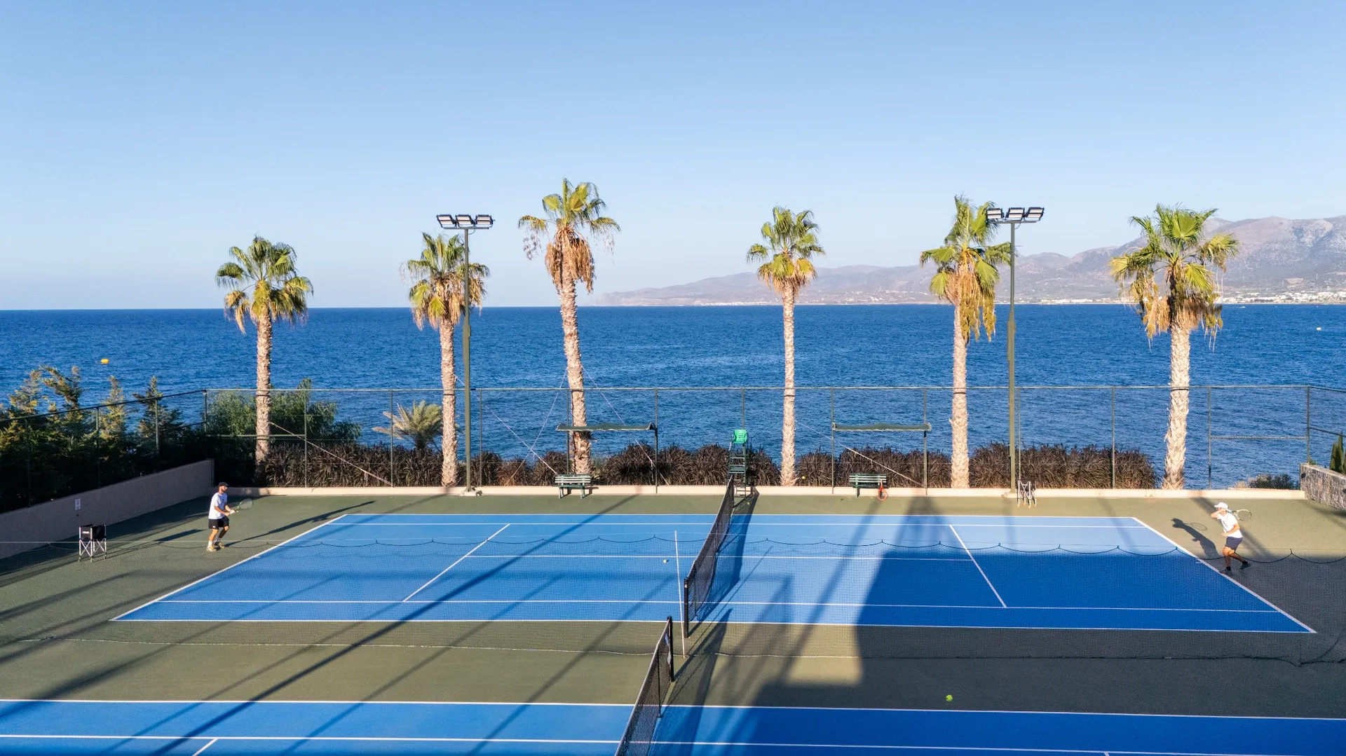 Blue tennis courts with sea view